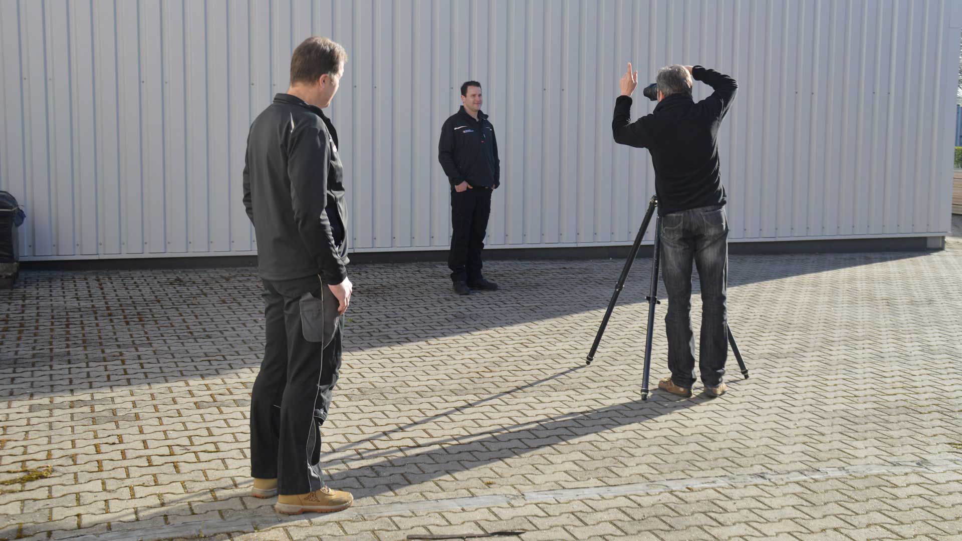 Andreas Mann fotografiert hier die Einzelfotos der Mitarbeiter von Hessels Deutschland - Making-of Teamfoto - schnell fotografieren, denn die Sonne dreht sich schnell.